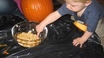 child playing with pumpkin